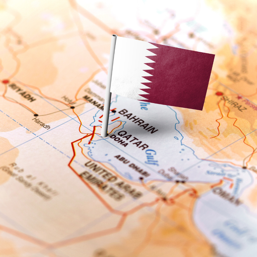 Close-up of a Qatar flag pinned on a map, highlighting its role in global natural gas exports.
